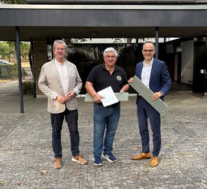 Staatssekretär Denis Alt übergibt einen Förderbescheid in Becherbach. v.l.n.r.: Verbandsgemeindebürgermeister Uwe Engelmann, Ortsbürgermeister Roland Riemenschnitter, Staatssekretär Denis Alt