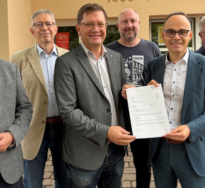Auf dem Bild sehen Sie Staatssekretär Dr. Denis Alt beim Überreichen des Förderbescheids.